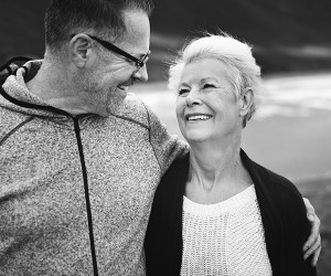 Older woman and man smiling while out for a walk