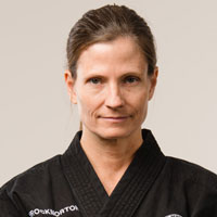 A lady wearing a black Taekwondo Gi